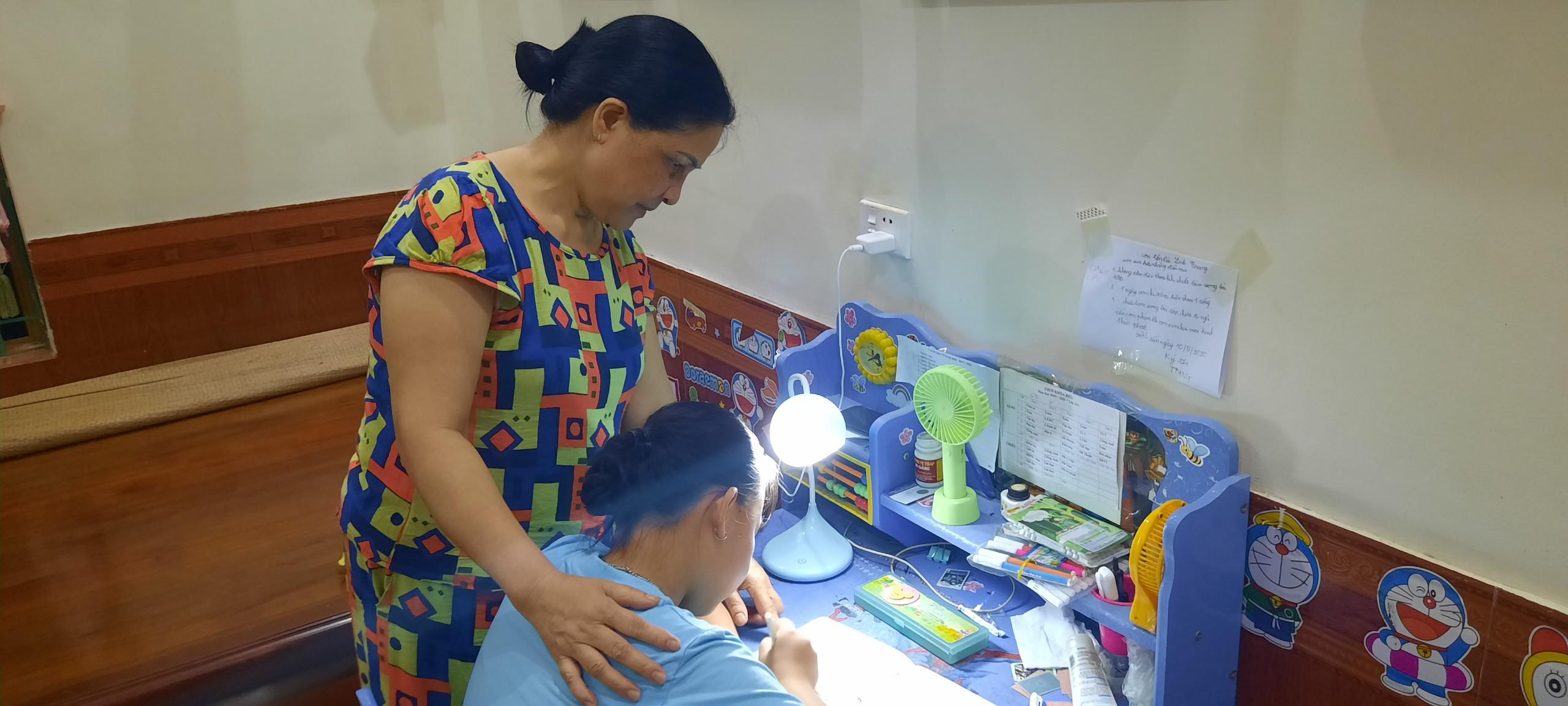 Ảnh: Phụ huynh học sinh hướng dẫn con học bài sau Tiếng trống Khuyến học của chi hội khuyến học xóm.