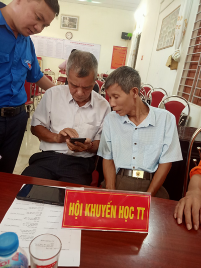 Ảnh: Cán bộ và nhân dân hưởng ứng việc cài đặt phần mềm “Công dân học tập”