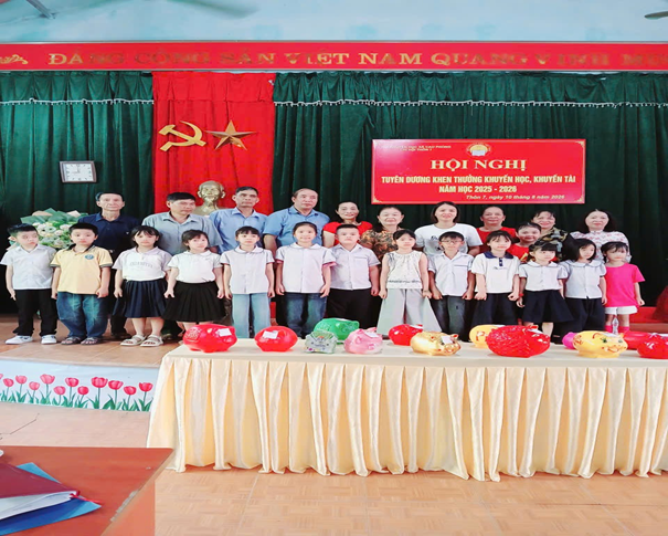 Ông Nguyễn Duy Nghĩa - Chủ tịch Hội khuyến học xã  cùng các đồng chí lãnh đạo thôn trao thưởng cho các cháu học sinh đạt học sinh giỏi