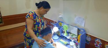 Ảnh: Phụ huynh học sinh hướng dẫn con học bài sau Tiếng trống Khuyến học của chi hội khuyến học xóm.